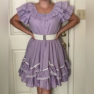 Purple puffy sleeved top with purple polka-dot skirt.